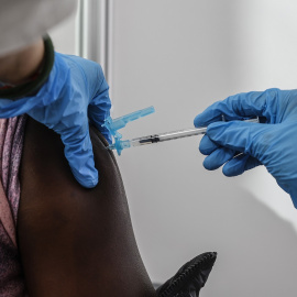 Una sanitaria vacuna a una persona con la tercera dosis de la vacuna de Moderna en el vacunódromo instalado en la Ciutat de Les Arts i les Ciències, en València