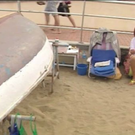 Una pareja vive bajo un barca en la playa de las Canteras en Las Palmas de Gran Canaria
