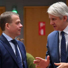 El ministro finlandés de Finanzas, Petteri Orpo, charla con su homólogo rumano, Eugen Teodorovici | AFP/ Emmanuel Dunand