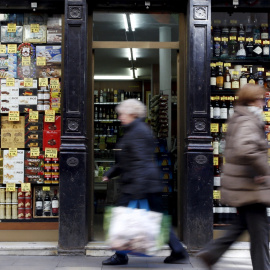 Varias personas pasan por delante de una tienda de alimentación en el centro de Barcelona. REUTERS/Albert Gea