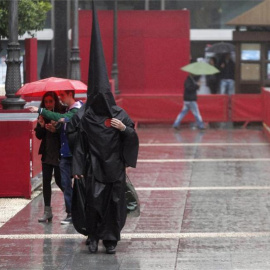 Imagen de archivo de un nazareno del Sepulcro que camina bajo la lluvia. SALAS / EFE