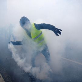 Un hombre, ataviado con un chaleco amarillo, lanza una granada de gas lacrimógeno.- Stephane Mahe/REUTERS