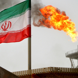 Un bandera de Irán cerca de una llamarada de gas en una plataforma de producción de petróleo en los campos petrolíferos de Soroush, en el Golfo Pérsico. REUTERS / Raheb Homavandi