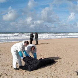 Operarios trasladan el cuerpo de uno de los migrantes del naufragio de la patera ocurrido el 5 de noviembre en Caños de Meca (Cádiz). / EFE