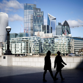 Dos personas pasean al lado del Támesis en Londres, con los edificios de la City, el distrito financiero, al fondo. REUTERS/Henry Nicholls