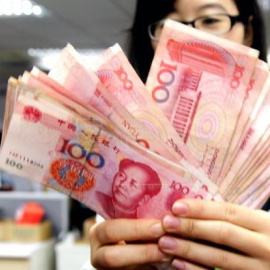 Fotografía de una trabajadora de una oficina postal con varios billetes de yuanes, en Pekín (China). Los ingresos fiscales de China aumentaron el 13,6 % en el primer trimestre del año. EFE/Archivo