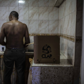 Un vecino de la parroquia 23 de enero prepara la cena con productos del Comité Local de Abastecimiento y Producción (CLAP) en su apartamento. JAIRO VARGAS