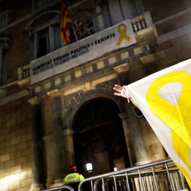 20/03/2019.- Una mujer muestra una pancarta con una lazo amarillo ante el Palau de la Generalitat. / EFE - ALEJANDRO GARCÍA