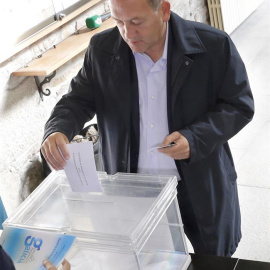 Un ciudadano introduce su voto en una urna durante las elecciones gallegas de este domingo.- EFE