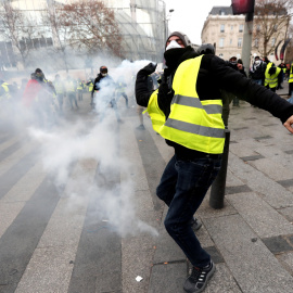 Un manifestante devuelve una granada de gas lacrimógeno a la Policía en París.- EFE/EPA/Ian Langsdon
