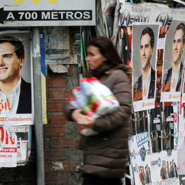 Una mujer pasa por una calle con los carteles de Albert Rivera.- EFE