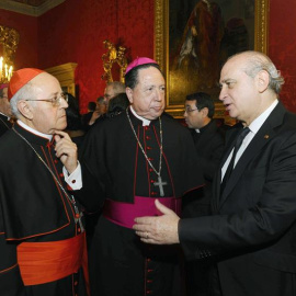 El ministro del Interior Jorge Fernández Díaz (d) charla con el cardenal Ricardo Blázquez (i) y con el arzobispo Castrense Juan del Río Martín (c), durante la recepción de ayer en la Santa Sede. EFE