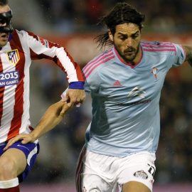 El delantero argentino del Celta de Vigo Joaquín Larrivey lucha un balón con el defensa uruguayo Diego Godín.- EFE