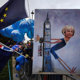 La artista Kaya Mar muestra un cuadro de la primer ministra británica Theresa May durante una manifestación en contra del brexit a las afueras del Parlamento en Londres. - EFE