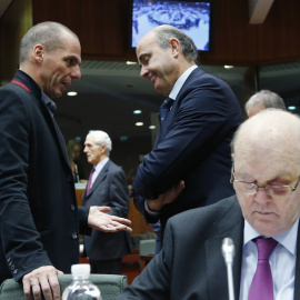 El ministro de Finanzas griego, Yanis Varoufakis, conversa con el mionistro español de Economía, Luis de Guindos, cerca de donde está sentado el ministro irlandés Michael Noonan, antes del comienzo de la reunión del Ecofin, en Bruselas. REUTERS/Franc