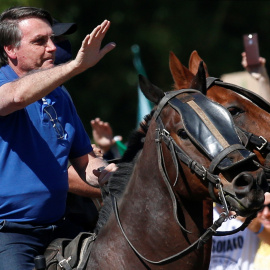 El presidente de Brasil, Jair Bolsonaro, monta a caballo y saluda a sus simpatizantes, en una manifestación en su favor en Brasilia. REUTERS/Ueslei Marcelino