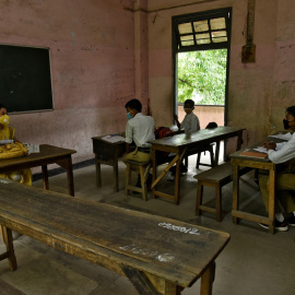 Estudiantes y su profesora con mascarilla en un aula de una escuela de la localidad de Guwahati, en el estado nororiental de Assam, en India. REUTERS/David Talukdar