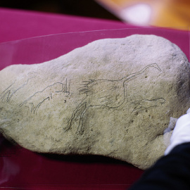 Imagen del hallazgo con un calco de las figuras grabadas superpuesto a la pieza