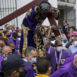 Fieles católicos portan una figura de Jesús con la cruz durante la procesión del Nazareno de San Pablo en el marco de las celebraciones de la Semana Santa en Caracas, el 31 de marzo de 2021.- AFP