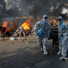 Trabajadores sanitarios incinerando los cuerpos de las víctimas fallecidas por coronavirus en Nueva Delhi. (Reuters)

