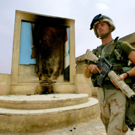  Un infante de marina estadounidense con la 15ª MEU pasa junto a un retrato quemado de Saddam Hussein mientras patrulla con su pelotón el 10 de abril de 2003 en la ciudad de An Nasiriyah en Irak. FOTO AFP / TIM SLOANTIM SLOAN / AFP