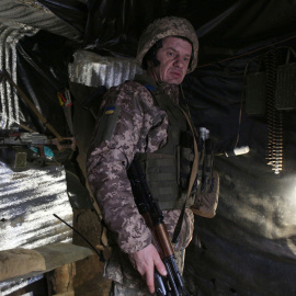  Un militar de las Fuerzas Militares de Ucrania observa en un refugio en primera línea con separatistas respaldados por Rusia cerca de Gorlovka, región de Donetsk, el 23 de enero de 2022. Anatolii STEPANOV / AFP