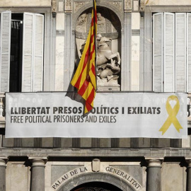 Vista del cartel reclamando la libertad de los líderes independentistas presos y un lazo amarillo en la fachada del Palau de la Generalitat. - EFE