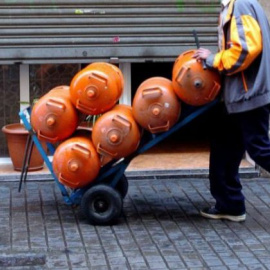 Un hombre carga seis bombonas de butano, en una imagen de archivo / EFE