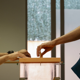 Foto de archivo de una persona introduciendo su voto en una urna