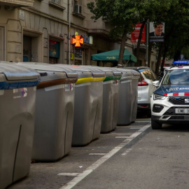 Un coche de la Policía aguarda junto a un contenedor del centro de Barcelona, a 29 de noviembre de 2022.