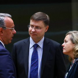 El ministro de Finanzas griego, Christos Staikouras, el comisario europeo Valdis Dombrovskis y la ministra de Economía española, Nadia Calvino, hablan durante el Ecofin celebrado este martes en Bruselas.