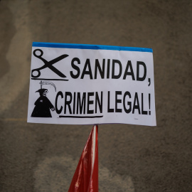 Una pancarta que reza 'Sanidad, Crimen Ilegal' durante una protesta de los trabajadores del servicio de atención telefónica de la centralita de atención de emergencias del Summa 112, que atiende el 061, frente a la Consejería de Sanidad, a 