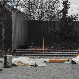 Un soldado ucraniano pasa junto a los cadáveres de una familia, que yacen en el suelo después del bombardeo del ejército ruso en el punto de evacuación de Irpin