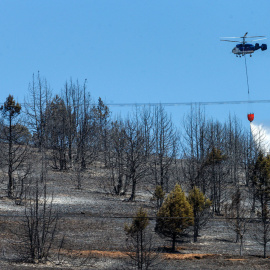 25/07/2022. Un helicóptero trabaja este lunes para extinguir el incendio que afecta desde ayer a la comarca del Arlanza en Burgos. Los tres grandes incendios que se han declarado este fin de semana en Castilla y León, aún activos, en Burgos