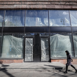 Una mujer rusa camina frente a las ventanas de un espacio comercial vacío en el centro de Moscú, Rusia, el 15 de marzo de 2022.