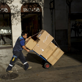 Un trabajador transporta cajas en el centro de Madrid./ REUTERS-Juan Medina