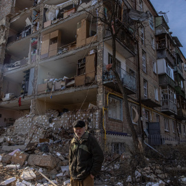 Un hombre camina este viernes por delante de un edificio residencial dañado por un bombardeo en el distrito de Podilskyi en Kiev, Ucrania.