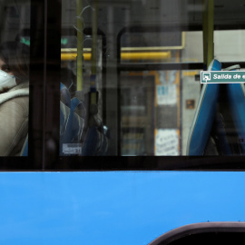 Una mujer con mascarilla mientras utiliza el transporte público en Madrid. REUTERS