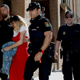 La mujer detenida como presunta autora del asesinato del hijo de acogida de su pareja sentimental sale tras el registro de un domicilio acompañada de agentes de la Policía Nacional. EFE/MORELL