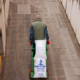 Untrabajador traslada una carretilla con un saco de hielo, en Ronda (Málaga). REUTERS/Jon Nazca