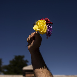 Un hombre levanta tres rosas de los colores de la bandera republicana durante un homenaje a las 13 Rosas y los 43 Claveles en el 82º aniversario de su fusilamiento, en el Cementerio de la Almudena, a 5 de agosto de 2021, en Madrid
