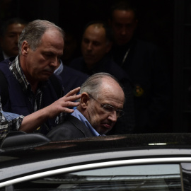 Un agente introduce a Rodrigo Rato en un coche policial. - AFP
