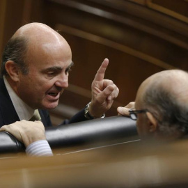 El ministro de Economía, Luis de Guindos, conversa con el titular de Hacienda, Cristóbal Montoro, en el Congreso de los Diputados. EFE/Paco Campos