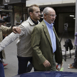 El exvicepresidente del Gobierno, Rodrigo Rato, acompañado de un guardaespaldas, sale de su domicilio donde numerosos medios de comunicación esperan noticias. EFE/Sergio Barrenechea