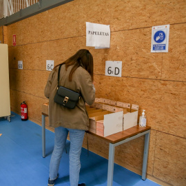 Una mujer elige su papeleta en las elecciones del 4 de mayo de 2021 en Madrid