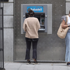 05/04/2022. Dos mujeres en un cajero de una sucursal de banco Sabadell, a 2 de septiembre de 2021, en Madrid, a 02/09/2021.