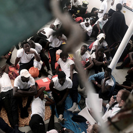 Los migrantes se sientan en la cubierta del 'MV Aquarius', el barco de búsqueda y rescate de Médicos sin Fronteras y SOS Mediterranee en el Mediterráneo. REUTERS