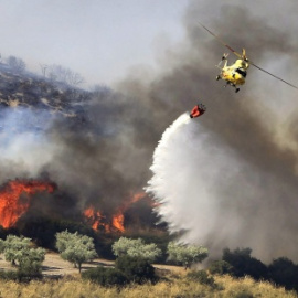 Un helicóptero participa en labores de extinción de un incendio en la Comunidad de Madrid.
