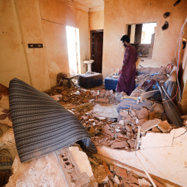 Un hombre busca entre sus pertenencias en una vivienda afectada por los combates en Jartum, a 17 de abril de 2023.