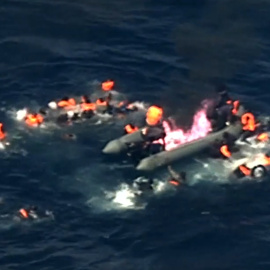 Imagen de la embarcación incendiada y de sus ocupantes en el agua.- FRONTEX